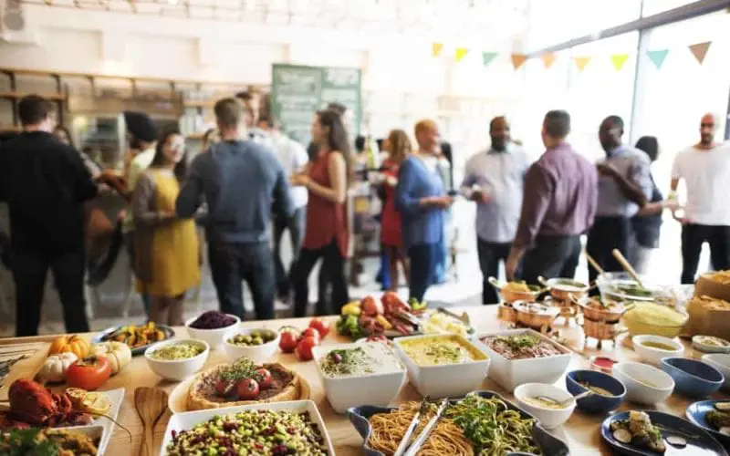 Multi-cultured buffet, with a crowd of mingling people.