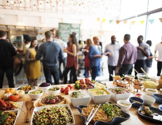 Multi-cultured buffet, with a crowd of mingling people.