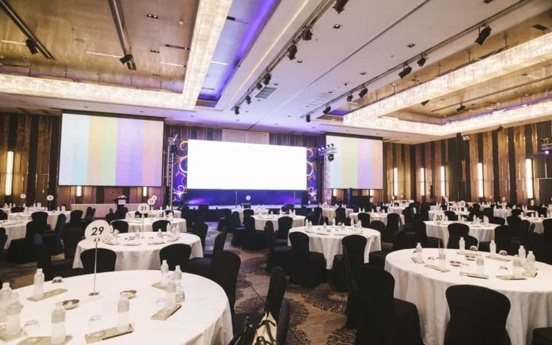 Event hall with cloaked chairs and tables.