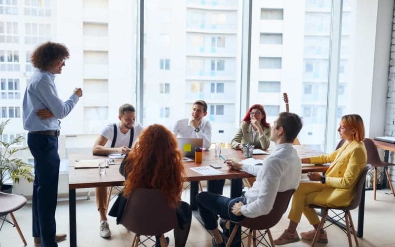 seven young business people taking a meeting