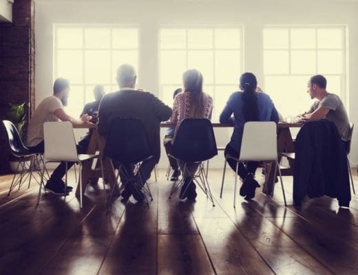 Well lit modern meeting, around conference table.