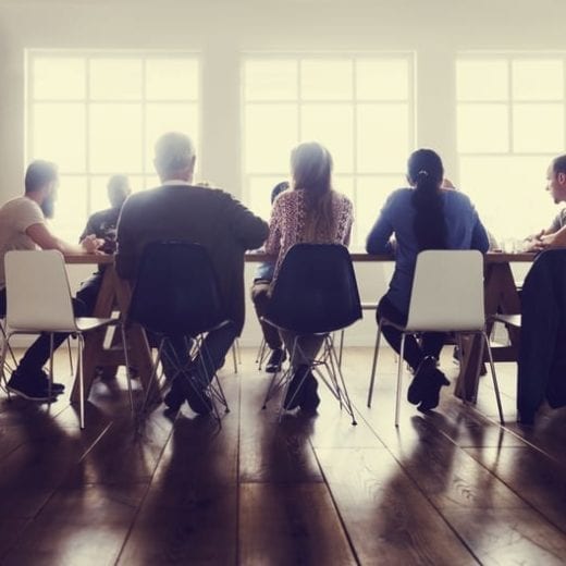 Well lit modern meeting, around conference table.