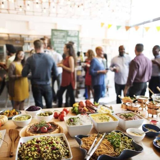 Groups of people talking in a room with a buffet