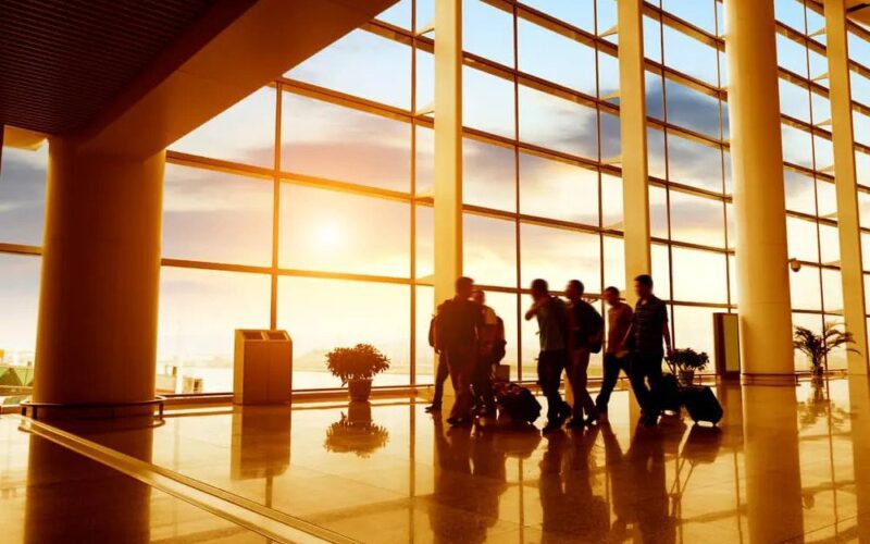 Travellers commuting through an airport at sundown